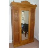 A 19TH CENTURY SATINWOOD WARDROBE with carved panels and central mirror door, fitted hanging rails