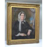 MID 19TH CENTURY BRITISH SCHOOL Portrait of a Lady, seated, a large cameo brooch at her neck, a book