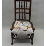 A NORTH OF ENGLAND SPINDLE BACK ARMCHAIR with rush seat, supported on low plain turned legs, with