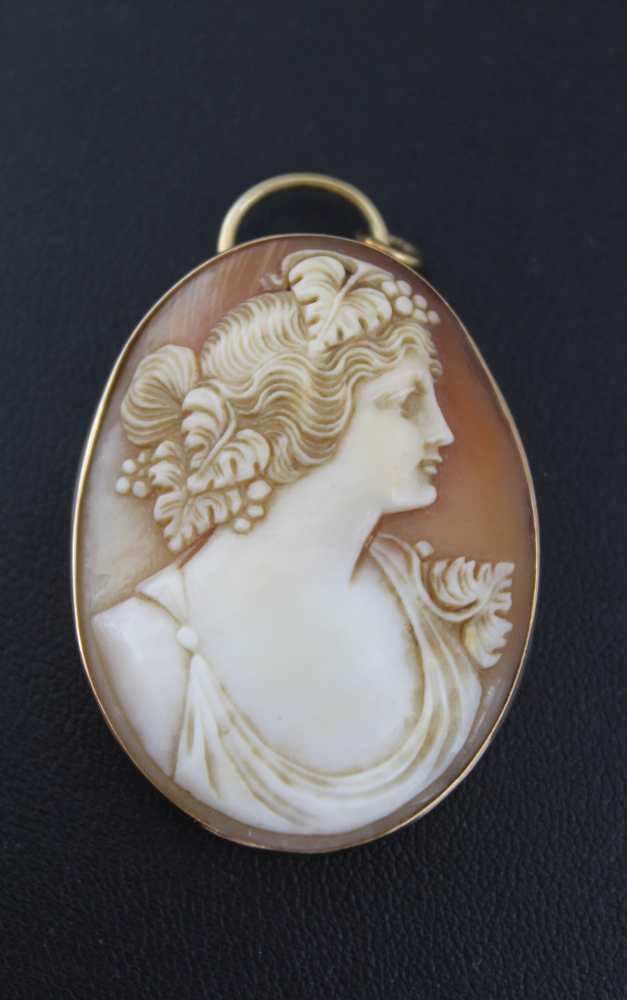 A CARVED SHELL CAMEO PENDANT, profile portrait of a young woman in classical taste, Bacchanalian