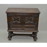 AN OAK CUPBOARD ON STAND, part 17th century, the rectangular plank top over a pair of panel doors