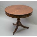 A REPRODUCTION MAHOGANY DRUM TABLE, the top fitted with four real and four dummy drawers, on vase