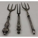 TWO SILVER HANDLED BREAD FORKS and a two prong fork with white metal figurative handle