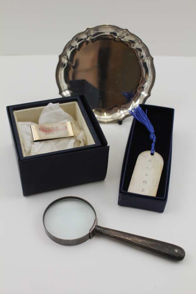 A SILVER-HANDLED MAGNIFYING GLASS, a SILVER NOTE CLIP (cased), a SILVER BOOKMARK (cased) and a