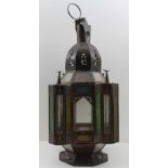 A MIDDLE EASTERN DESIGN LANTERN, the pierced decorative metal frame inset clear and coloured glass