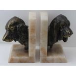 A PAIR OF CONTINENTAL BOOKENDS alabaster stands with bronzed cast metal dog head mounts, 20cm high