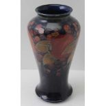 A MOORCROFT POTTERY VASE OF BALUSTER FORM, tube lined and painted pomegranate design on a mottled