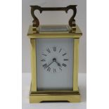 A BRASS FRAMED CARRIAGE CLOCK, bevel glass panels, white enamel face with Roman numerals, height