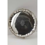 BARKER BROTHERS AN EDWARDIAN SILVER WAITER, having pie-crust rim, on four pad feet, central engraved