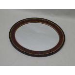 AN EARLY 20TH CENTURY OVAL BEVEL PLATE WALL MIRROR in fancy wooden frame, with applied cast gilt