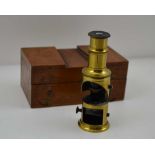A SMALL BRASS MONOCULAR MICROSCOPE in a polished wood case, the box 10cm x 6cm x 4.5cm