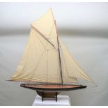 A 20TH CENTURY YACHT, partial ebonised hull, planked deck with brass fittings, fully rigged with