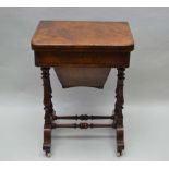 A VICTORIAN WALNUT GAMES / WORK TABLE having foldover revolving top, revealing checkerboard,