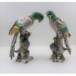 A PAIR OF 20TH CENTURY CONTINENTAL PORCELAIN PARROTS, painted and gilded, perched upon blossom