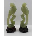 A PAIR OF CHINESE CARVED JADE HO-HO BIRDS, perched pose, 17cm high, together with carved hardwood