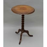 A 19TH CENTURY SNAP TOP WINE TABLE on bobbin turned stem with triform supports, 44cm in diameter