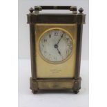 A BRASS FRAMED CARRIAGE CLOCK, with bevel glass panels, silvered dial with Arabic numerals inscribed