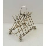 A 19TH CENTURY NOVELTY SILVER-PLATED TOAST RACK, decorated with croquet balls, mallets and a hoop