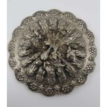 A TURKISH WHITE METAL FRAMED AND BACKED PETAL EDGE MIRROR with repousse decoration, mounted with a