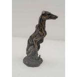 A 20TH CENTURY CAST BRONZE SEATED LONG DOG, 10cm high