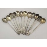 TWELVE 19TH CENTURY RUSSIAN WHITE METAL TEASPOONS with barley twist stem handles, with engraved