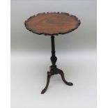 A 19TH CENTURY MAHOGANY SNAP-TOP WINE TABLE having pie-crust rim, on fluted stem and carved tripod