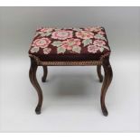 A 19TH CENTURY STOOL, mahogany cabriole legs, with woolwork floral top, 40cm x 32cm