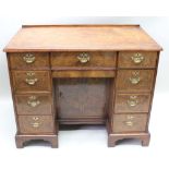 A WALNUT FINISHED GEORGIAN DESIGN LATE 19TH / EARLY 20TH CENTURY KNEEHOLE DESK with feather