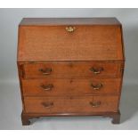 A GEORGE III OAK FALL FRONT WRITING BUREAU, over three long drawers with brass handles, on bracket