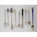 NINE VARIOUS SILVER AND WHITE METAL PICKLE FORKS, includes a blue enamel handled example with