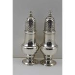 A PAIR OF GEORGIAN DESIGN SILVER SUGAR SIFTERS of baluster form, raised on domed bases, engraved