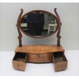A 19TH CENTURY MAHOGANY BOW FRONT DRESSING TABLE MIRROR, having oval framed plate over three drawers
