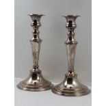 A PAIR OF GEORGIAN DESIGN SILVER-PLATE ON COPPER CANDLESTICKS, on circular stepped bases, marked "