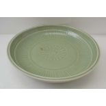 A CHINESE CELADON CERAMIC SHALLOW BOWL, incised floral central decoration, 26.5cm in diameter, bears