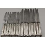 ROBERTS & BELK LTD. A SET OF EIGHT DINNER KNIVES with plated scallop terminal handles and a matching