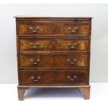 A GEORGIAN DESIGN WALNUT VENEER BACHELOR CHEST of four long drawers with brass handles, fitted