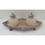 A SILVER PLATED INKSTAND TRAY with decorative rim and two cut glass lidded wells, tray 26cm