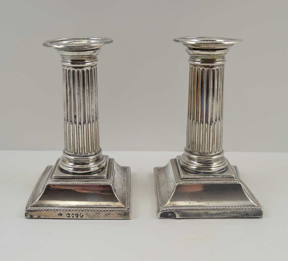 RUPERT FAVELL A PAIR OF VICTORIAN SILVER CANDLESTICKS of column design, on stepped square bases,
