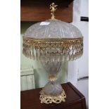 A CUT GLASS & GILT METAL TABLE LAMP having cast figural finial, and faceted pear shaped drop fringe