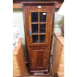 A SMALL SIZED MAHOGANY FINISHED CORNER CUPBOARD, with glazed upper door and plain panelled lower