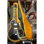 A HARD CASED LES PAUL DESIGN BLACK FINISHED ELECTRIC GUITAR, with gold hardware, bearing the