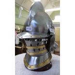 A REPRODUCTION KNIGHTS HELMET on stand
