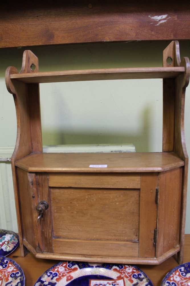 A SMALL HANGING CUPBOARD with upper shelf