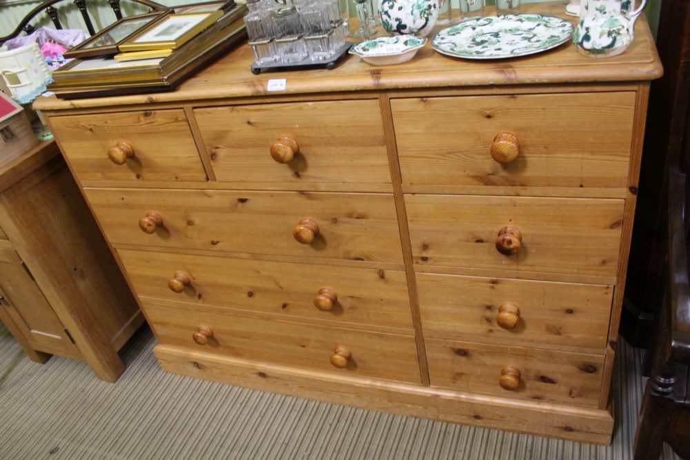 A LATE 20TH CENTURY PINE DOUBLE WIDTH CHEST OF NINE DRAWERS, on a plain plinth base