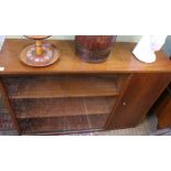 A RETRO TEAK FINISHED SIDE UNIT having twin sliding glass doors, flanking a single solid cupboard