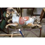 A MID-CENTURY TIN PLATE ROCKING HORSE on stand, having remains of original trade label 'Prairie