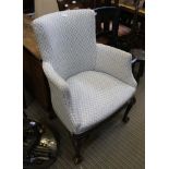 AN EARLY 20TH CENTURY UPHOLSTERED TUB ARMCHAIR, with blue patterned trellis upholstery, having