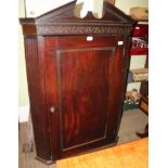 AN OVERSIZED 19TH CENTURY MAHOGANY CORNER CUPBOARD with swan neck pediment and blind fret frieze