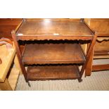 AN OAK THREE-TIER TEA TROLLEY on original castors