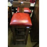 A PAIR OF OAK LOW BACKED SQUARE PAD SEATED BAR STOOLS